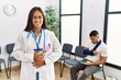 © Krakenimages.com - Young asian doctor woman at waiting room with a man with a broken arm with hand on stomach because indigestion, painful illness feeling unwell. ache concept.