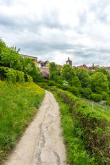 Sticker - A vertical shot of a rural trail through a valley to Rothenburg ob der Tauber, Germany