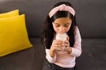 Wall Mural - Healthy little girl drinking milk