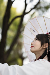 A young woman in Chinese traditional style dress with an umbrella.