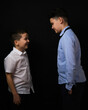 © Сергей Везнер - Two boys on a black background are brothers.Senior and junior.Atelier.The younger one laughs at the older one