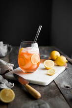 A Pink Lemonade On A Cutting Board With Fresh Lemons