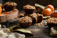 Persimmon Muffins In A Rustic Kitchen, With Fresh Persimmons