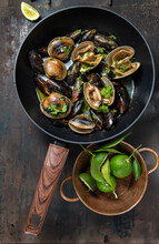 Clams And Mussels In Pan With Beer. Metal Background