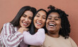 Happy multiracial friends embracing and smiling in front of camera