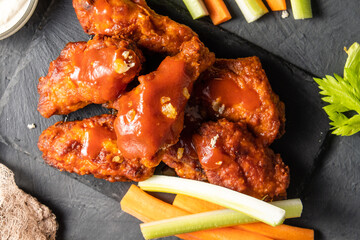 BBQ chicken wings on slate, dark table. View from above.