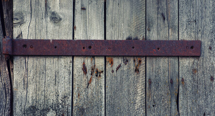 Wall Mural - Old weathered wooden door with steel hinges. Distressed panels. Old wall texture background. Detail of an old wooden door with rusty door latch.