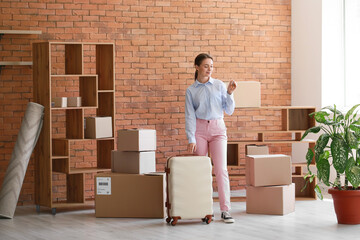 Wall Mural - Young woman with key and suitcase in her new flat