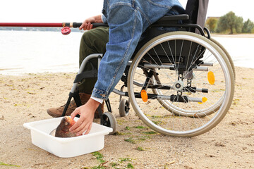 Canvas Print - Man in wheelchair fishing on river