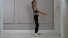 Little Girl In Sports Clothes Doing Bridge Pose On The Floor In A Living Room
