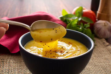 Hot cassava cream broth in a white bowl, on a wooden table