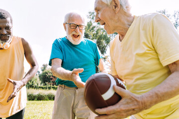 Wall Mural - Group of senior friends playing at the park. Old multiethnic friends making activities outdoor. Concept about third age and lifestyle