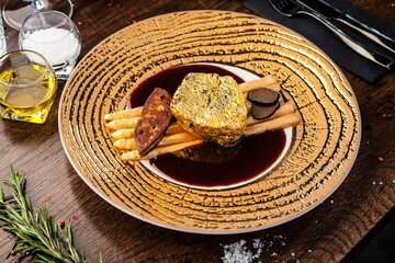 Black Angus 24 carat gold steak. Beef tenderloin, foie gras, fresh black truffle, white asparagus, port wine sauce. Delicious food closeup served for lunch in modern gourmet cuisine restaurant