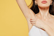 © ViDi Studio - Cropped close up photo young brunette woman 20s in white brassiere underwear raise up hand show soft perfect shaved armpit isolated on plain yellow background studio. Female beauty bodycare concept.
