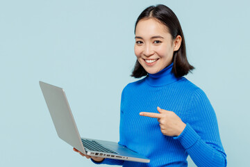 excited young woman of asian ethnicity 20s years old wear blue shirt hold use work on laptop pc comp