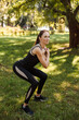 © Ankor_stock. - Young woman in sports uniform doing exercises for squats in the city park.