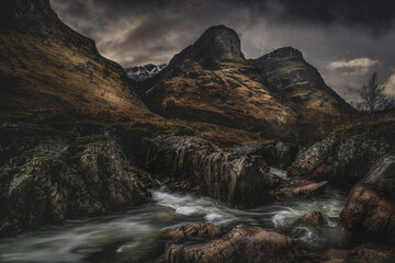 Wall Mural - Glencoe Scotland, the three sisters and waterfalls. Dramatic stormy sky landscape photography of this iconic Scottish Highlands landmark. 