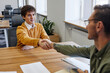 © Seventyfour - Portrait of smiling young man shaking hands with HR manager at job interview in office, copy space