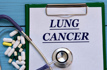 LUNG CANCER - word on a white sheet on a blue background with tablets and a stethostecop