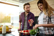 © Taras Grebinets - Beautiful delighted pregnant woman and her loving husband preparing lunch together at home kitchen with large windows overlooking the garden. Maternity, healthy eating, family relationships concept