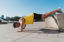 Athletic Young Man Doing Incline Push-ups Outdoors.