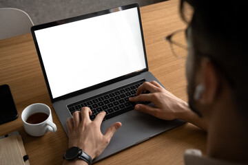 Man working using laptop with blank white screen mockup template