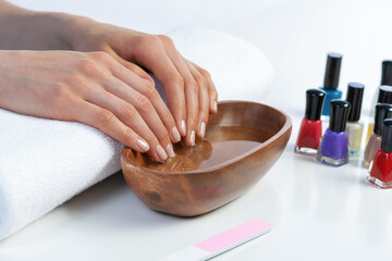 Wall Mural - Closeup female hands in wooden bowl with water