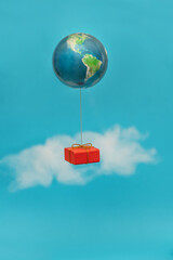 A gift tied to a balloon in the form of a globe flies through the sky