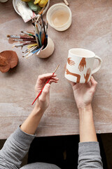 Female ceramist working in pottery studio. Ceramist's Hands Dirty Of Clay. Process of creating pottery. Master ceramist works in her studio