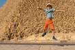 Happy boy jumping in front of the Cheops pyramid on the Giza plateau.