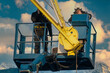 © Mike Mareen - Assemblers repairing a harbor crane on a high lift