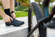 Cyclist Tying Shoelace By Bicycle