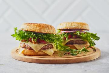 Wall Mural - Two burgers with veal cutlet and herbs on wooden cutting board