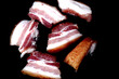 Juicy and tasty bacon is fried in a pan.
