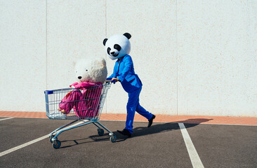 Storytelling image of a couple wearing giant panda head. Man and woman celebrating outdoor and making party