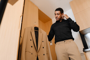 Canvas Print - Black man listening music with earphones and holding his jacket