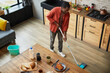 High angle portrait of young African-American man mopping floors while cleaning cozy apartment, copy space