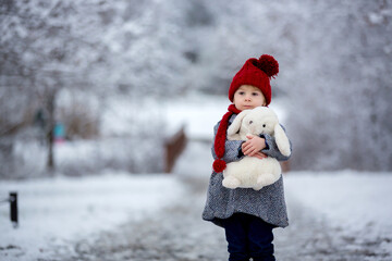 Wall Mural - Beautiful toddler child, cute boy, playing in snowy park winter time