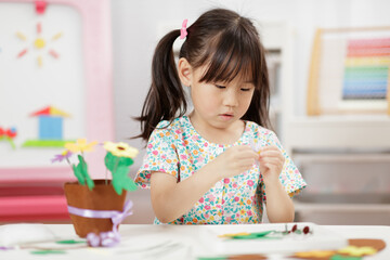 young girl making flower pot craft for home schooling