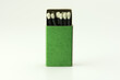 © killykoon - black match sticks with white tips, in a green match box, isolated on natural white background. Focus on match tips