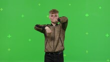 Close-up of young man dancing on a green screen background. Attractive guy making heart sign with hands. Modern blogger creating a master class. Chroma key