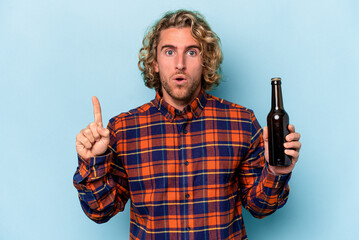 Wall Mural - Young caucasian man holding beer isolated on white background having some great idea, concept of creativity.