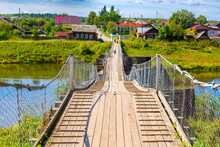 Old Picturesque Wooden Suspension Bridge Over The Tura River In The Town Of Verkhoturye On A Summer Sunny Day
