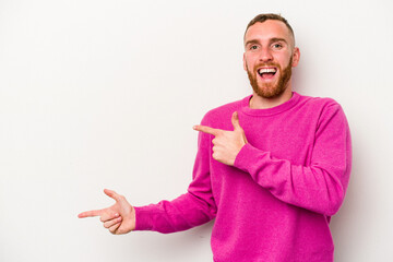 Young caucasian man isolated on white background excited pointing with forefingers away.