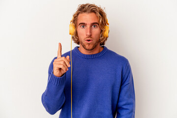 Wall Mural - Young caucasian man listening to music isolated on white background having some great idea, concept of creativity.