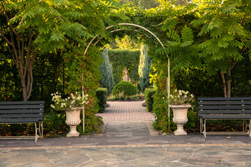 Landscaping of the park, green arches from plants. Trees, bushes, flower beds.