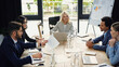 © LIGHTFIELD STUDIOS - young businessman holding infographics during meeting with multiethnic colleagues