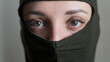 © Ольга  - Female portrait of young girl wearing khaki balaclava, only eyes are visible, mandatory conscription, military, feminism, equality concept