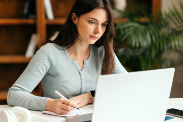 Cute woman learning with laptop at home. Student girl working on computer. work from home, freelance, online learning, studying, lockdown concept. Distance education. telework