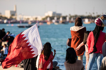 Doha, Qatar - December 18, 2017: The local population of Qatar with national flag at Qatar national day celebration.